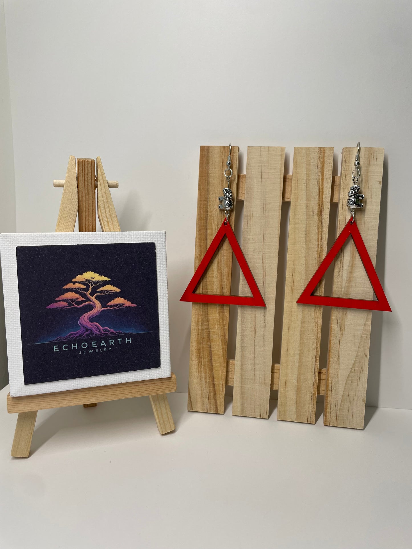 Wooden wall art with red triangles and a framed album cover on a white background