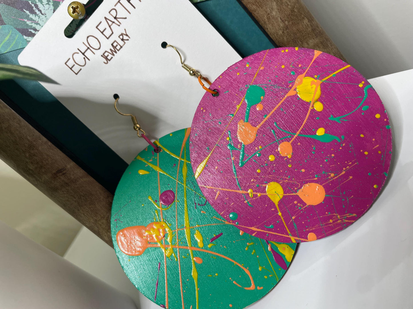 Colorful abstract-patterned earrings on a white card with 'Echo Earth' branding.