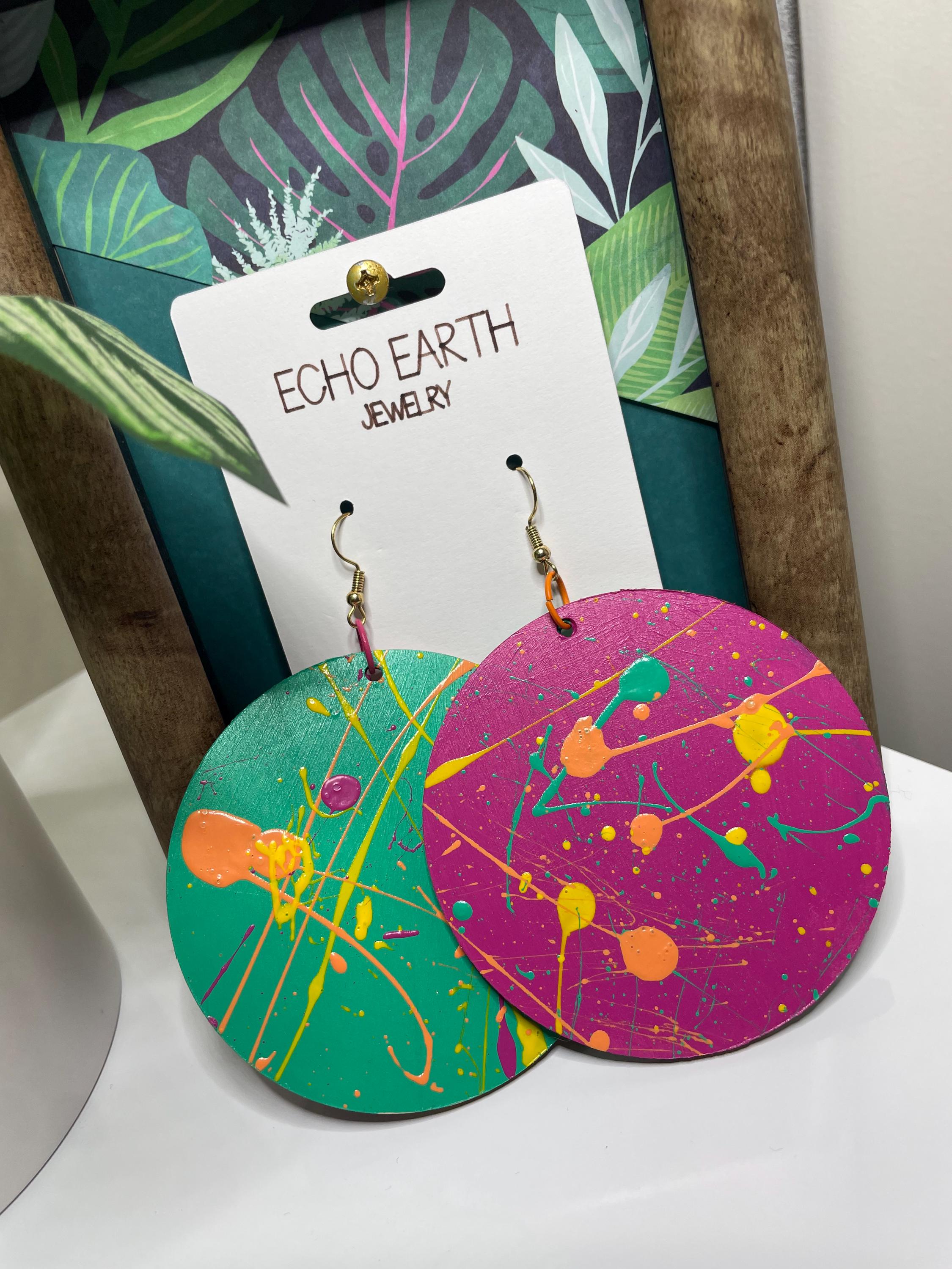 Colorful circular earrings with abstract design on a white surface, branded 'Echo Earth Jewelry'.